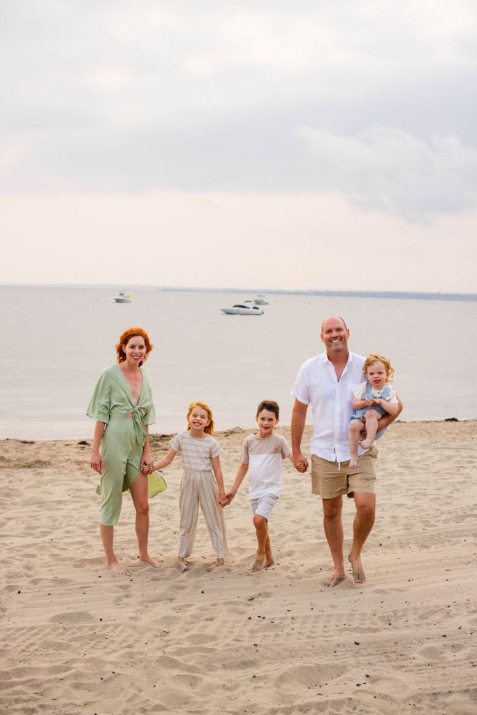 Family walking in the sand at their family beach portrait session in Narragansett with a RI family photographer in the point judith area