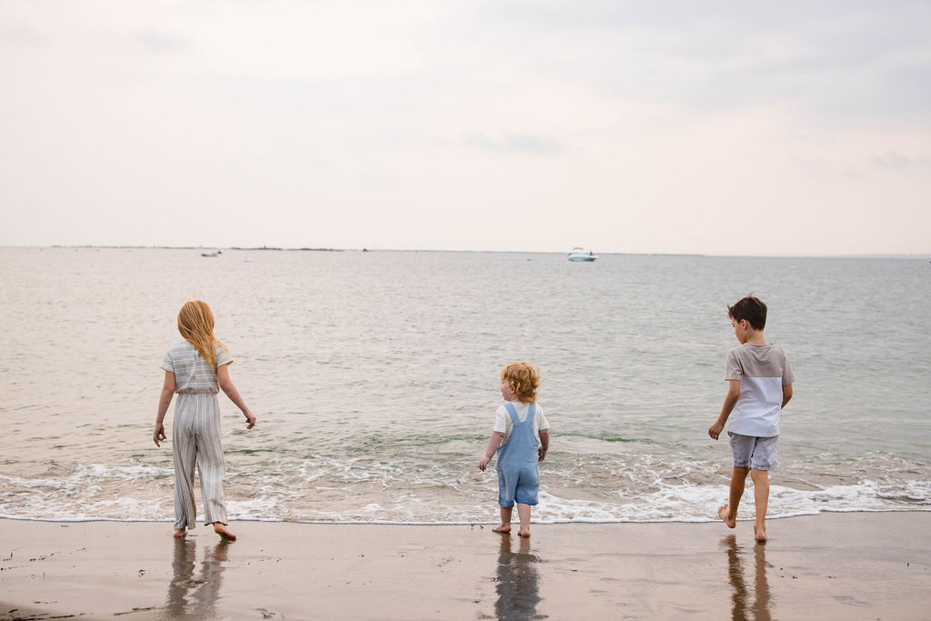 Kids playing in the water at their family beach portrait session in Narragansett with a RI family photographer in the point judith area
