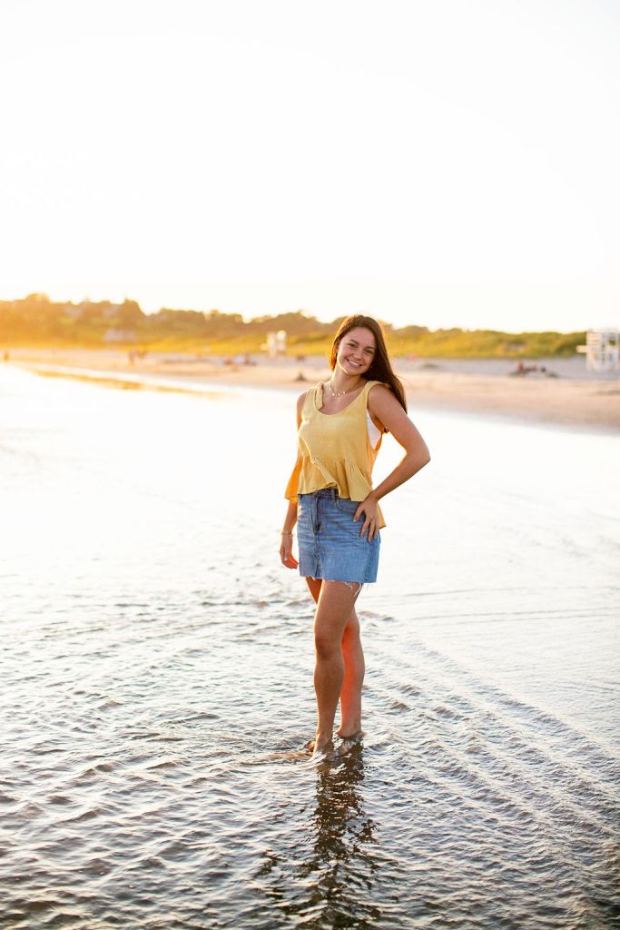 Girl poses for her senior session on the beach in Newport, RI