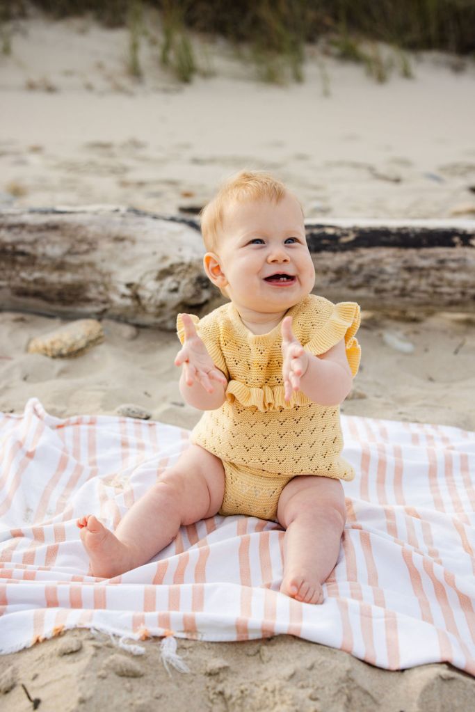 baby sitting on the beach, posing for photographer on block island