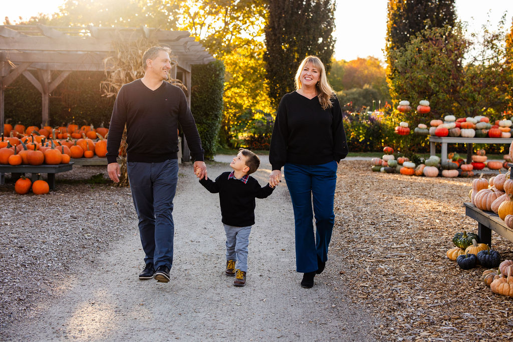 Family walks together through The Farmer's Daughter in Kingstown, RI for their fall portrait session