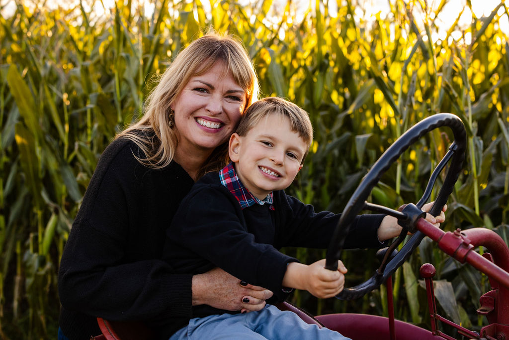 Mother and son pose next to the corn field at The Farmer's Daughter in Kingstown, RI for their fall portrait session